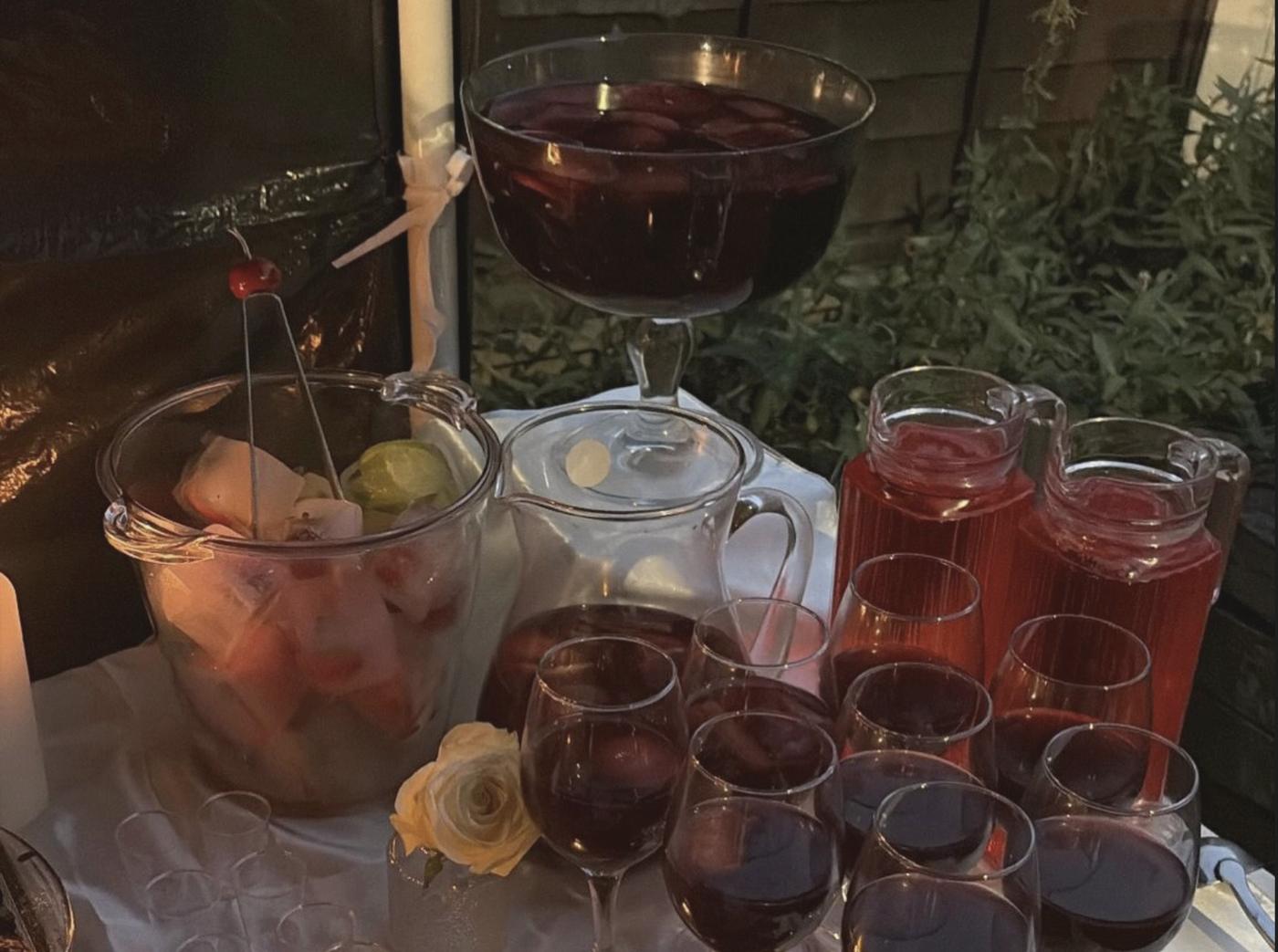 Evening drinks table with punch, pitchers, glasses and a white rose